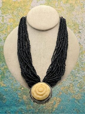 Vintage Multi Strand Black Seed Bead Necklace with Carved Bone Medallion